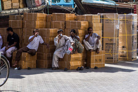 Hindu and Pakistani workers in the port of rest break in Dubai Creekのeditorial素材