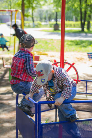two boys play on the playground in the iron boatの写真素材