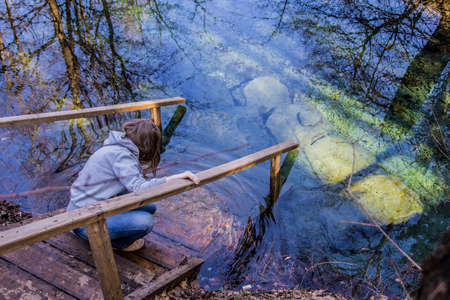 girl sitting on the jetty in the mineral spring