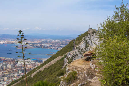 background landscape view of the top of the Rock of Gibraltar, an abandoned military battery, a weather station and city belowの写真素材