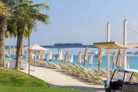 background landscape view of beach on the island of Palma with umbrellas and sunbeds, overlooking the Persian Gulf and the monorailの写真素材