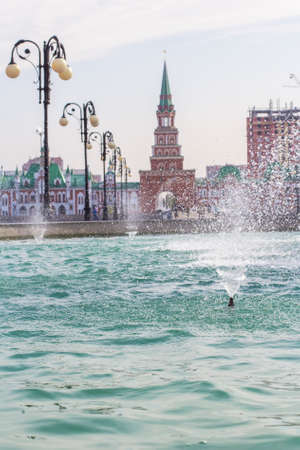 Background cityscape view of the bridge, Spassky tower and fountain in the center of Yoshkar-Ola, Mari El, Russiaの写真素材