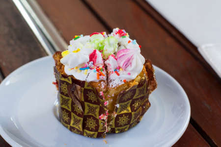 image little Easter cake on a saucer in the cafe on the wooden tableの写真素材