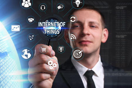 Business, Technology, Internet and network concept. Young businessman working on a virtual screen of the future and sees the inscription: internet of thingsの写真素材