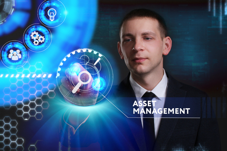 Business, Technology, Internet and network concept. Young businessman working on a virtual screen of the future and sees the inscription: Asset managementの写真素材