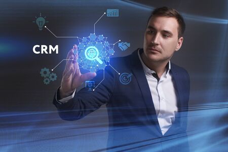 Business, Technology, Internet and network concept. Young businessman working on a virtual screen of the future and sees the inscription: CRMの写真素材