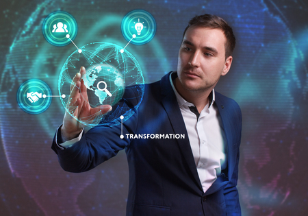 Business, Technology, Internet and network concept. Young businessman working on a virtual screen of the future and sees the inscription: Transformationの写真素材