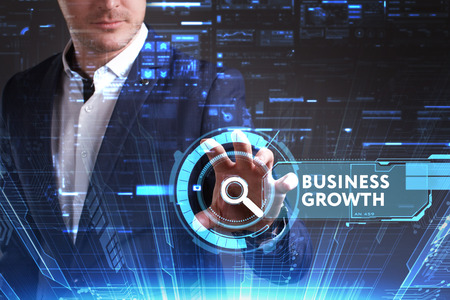 Business, Technology, Internet and network concept. Young businessman working on a virtual screen of the future and sees the inscription: Business growthの写真素材