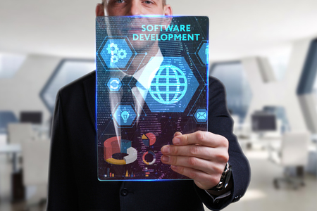 Business, Technology, Internet and network concept. Young businessman working on a virtual screen of the future and sees the inscription: Software developmentの写真素材