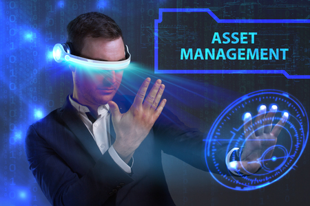Business, Technology, Internet and network concept. Young businessman working on a virtual screen of the future and sees the inscription: Asset managementの写真素材