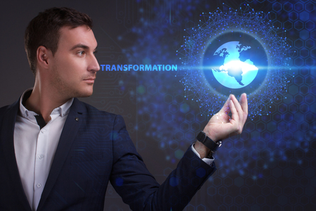 Business, Technology, Internet and network concept. Young businessman working on a virtual screen of the future and sees the inscription: Transformationの写真素材