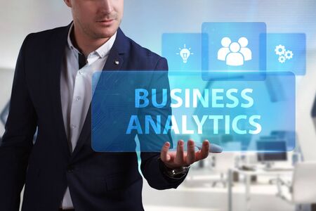 Business, Technology, Internet and network concept. Young businessman working on a virtual screen of the future and sees the inscription: Business analyticsの写真素材