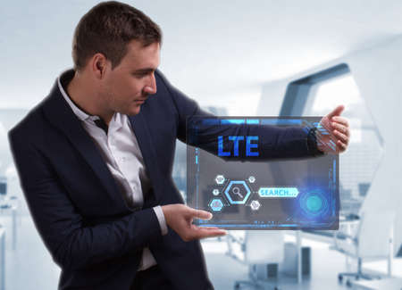 Business, Technology, Internet and network concept. Young businessman working on a virtual screen of the future and sees the inscription: LTEの写真素材