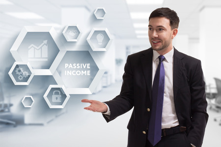 The concept of business, technology, the Internet and the network. A young entrepreneur working on a virtual screen of the future and sees the inscription: Passive incomeの写真素材