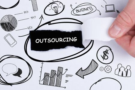 Business, technology, internet and networking concept. Young entrepreneur showing keyword: Outsourcingの写真素材