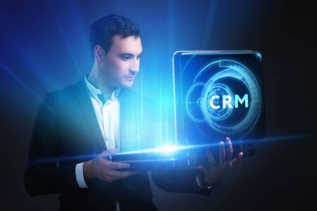 The concept of business, technology, the Internet and the network. A young entrepreneur working on a virtual screen of the future and sees the inscription: CRMの写真素材