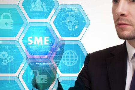 The concept of business, technology, the Internet and the network. A young entrepreneur working on a virtual screen of the future and sees the inscription: SMEの写真素材