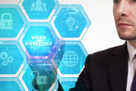 The concept of business, technology, the Internet and the network. A young entrepreneur working on a virtual screen of the future and sees the inscription: Video marketingの写真素材