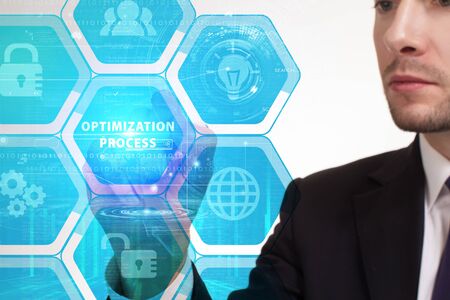 The concept of business, technology, the Internet and the network. A young entrepreneur working on a virtual screen of the future and sees the inscription: Optimization processの写真素材
