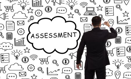 Business, technology, internet and networking concept. Young entrepreneur showing keyword: Assessmentの写真素材
