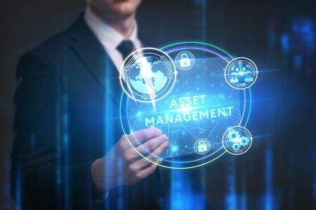 Business, Technology, Internet and network concept. Young businessman working on a virtual screen of the future and sees the inscription: Asset managementの写真素材