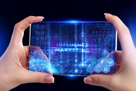 Business, Technology, Internet and network concept. Young businessman working on a virtual screen of the future and sees the inscription: Influence marketingの写真素材