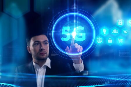 Business, Technology, Internet and network concept. Young businessman working on a virtual screen of the future and sees the inscription: 5Gの写真素材