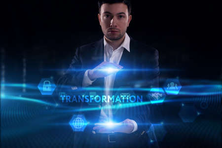 Business, Technology, Internet and network concept. Young businessman working on a virtual screen of the future and sees the inscription: Transformationの写真素材