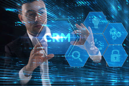Business, Technology, Internet and network concept. Young businessman working on a virtual screen of the future and sees the inscription: CRMの写真素材