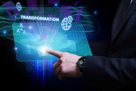 Business, Technology, Internet and network concept. Young businessman working on a virtual screen of the future and sees the inscription: Transformationの写真素材