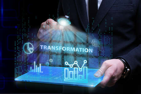 Business, Technology, Internet and network concept. Young businessman working on a virtual screen of the future and sees the inscription: Transformationの写真素材