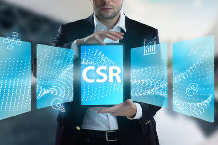 Business, Technology, Internet and network concept. Young businessman working on a virtual screen of the future and sees the inscription: CSRの写真素材