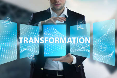 Business, Technology, Internet and network concept. Young businessman working on a virtual screen of the future and sees the inscription: Transformationの写真素材