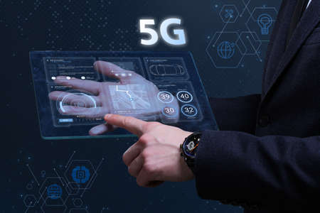 Business, Technology, Internet and network concept. Financial Graph. Stock Market chart. Young businessman working on a virtual screen of the future and sees the inscription: 5Gの写真素材