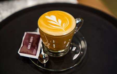 Waitress holding tray with cappuccino at the restaurantの写真素材