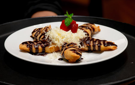 Crispy Fried banana flitters with cheese and chocolate sauce in white plate Asian style dessertの写真素材