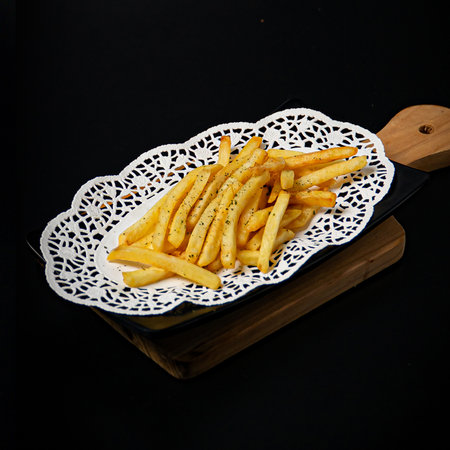 Plate of tasty French fries on black backgroundの写真素材
