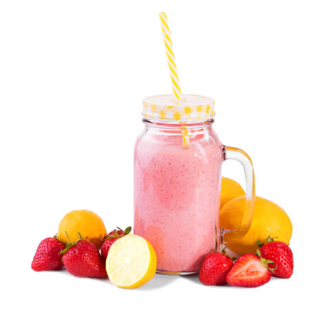 The jug with a tasty, fresh and summer beverage with ripe and juicy yellow lemons and bright red and sweet strawberries, isolated on a white background.の写真素材