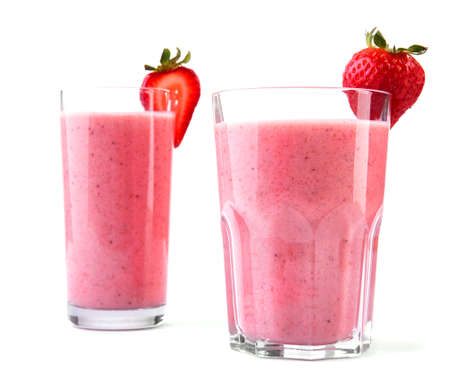 Two large glasses with pink drinks or beverages from juicy and fresh red strawberries and milk in with a small strawberry in the top of the glass, isolated on a white background.  Fruit beverage with strawberries and milk.の写真素材