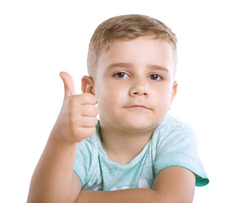 Close-up portrait of a beautiful and cute little child with pretty smiling. A Happy little boy is showing thumbs-up, indicating that everything is well, isolated on a white background.の写真素材