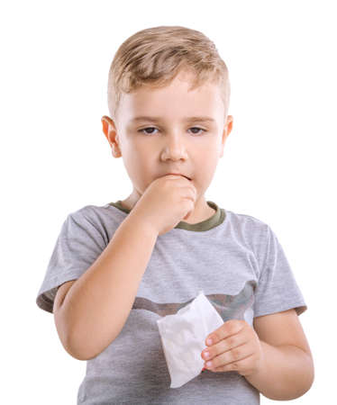 Close-up portret of marvelous and fabulous boy is eating appetising French fries isolated on a white background. Adorable young child dressed in a gray T-shirt is holding a box of food in his hand.の写真素材