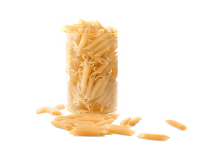 Raw and bright yellow pasta in a huge transparent glass, isolated on white background. Pasta, macarons, noodle, spaggeti in a glass. A huge glass full of raw and bright Italian food pasta.の写真素材