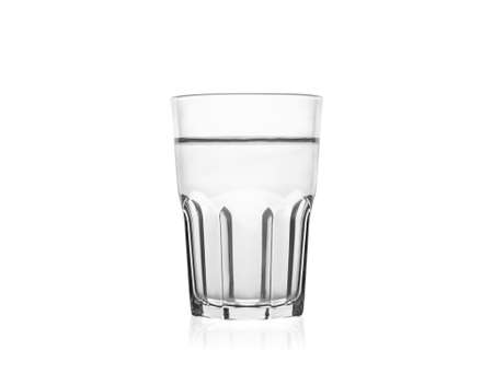 A big empty transparent water drinking glass for water, juice, milk and alcohol on a dark brown wooden table, isolated on a white background.の写真素材