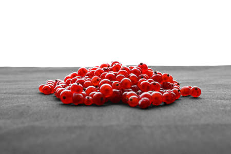 Macro ripe red berries on a bright isolated background. Juicy red currant laying on a spacious gray piece of cloth. Delicious nutritious ingredient.の写真素材