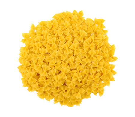 The heap of farfalle pasta a top view, isolated on a white background. Traditional farfalle Italian macaroni. Bright yellow and raw pasta. Flour products.の写真素材