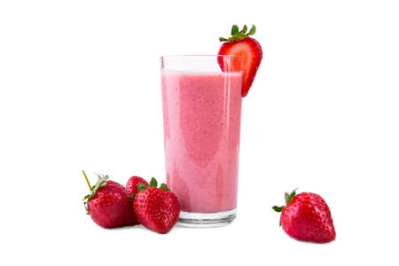 A transparent glass of strawberry smoothie, isolated on a white background. Strawberry yogurt with ripe berries and organic milk in a glass and fresh strawberries around. Yogurt with fresh berries.の写真素材