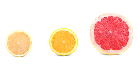 Three different citruses isolated on a bright background. A delicious red grapefruit, yellow lemon and refreshing orange cut in half. Beautiful juicy texture.の写真素材