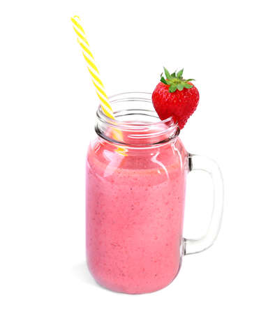 A delicious vegetarian saturated pink smoothie isolated on a white background. Organic strawberry beverage in a mason jar with a striped straw and a red berry on top. Nutritious diets.の写真素材