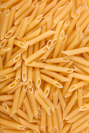 Italian penne rigate macaroni pasta and raw food on the background. Macaroni, noodle, and spaghetti in stock. Raw and fresh flour product. Macaroni texture. Full frame of dry pasta.の写真素材