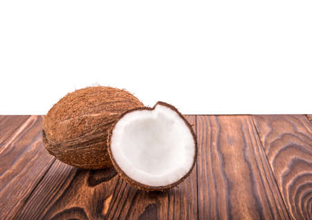 Tasty tropical coconut on a dack brown wooden table, isolated on a white background. Brown natural tropical and fresh fruit coconut. Close-up of tasty coconuts.の写真素材